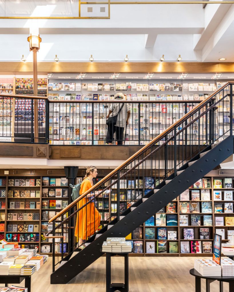 Woman walking up stairs in a bookstore in the Upper West Side near 720 West End Avenue